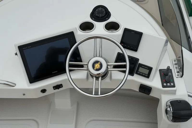 Tug Life Yacht Photos Pics 2017 Ranger Tugs R-29 CB helm with steering wheel, navigation screens, and controls.