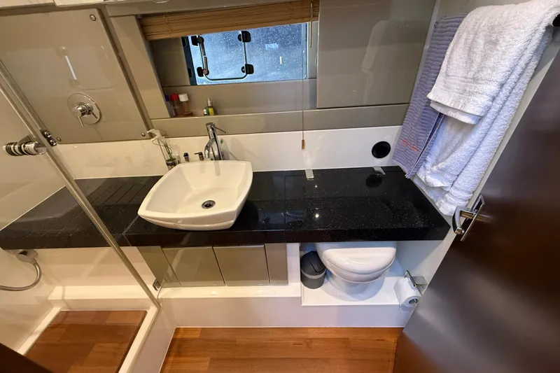  Yacht Photos Pics Luxurious bathroom in 2013 Fairline Targa 62 GT yacht with modern fixtures and wooden flooring.