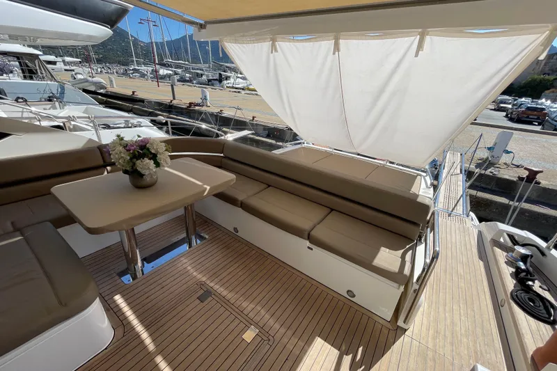  Yacht Photos Pics Luxurious 2013 Fairline Targa 62 GT yacht deck with seating and table, docked at marina.