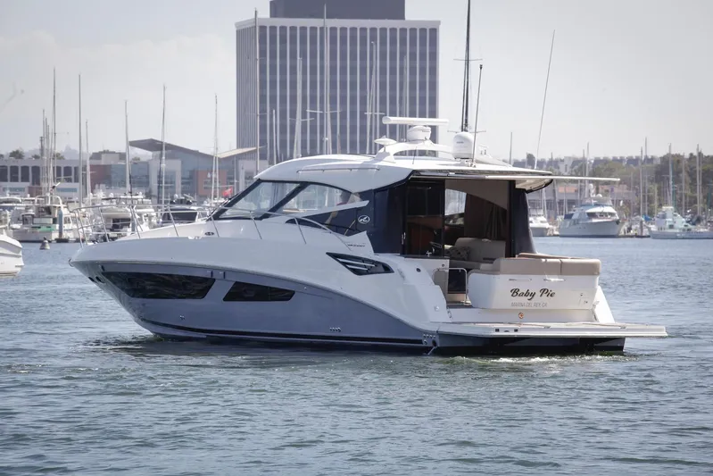 Baby Pie Yacht Photos Pics 2016 Sea Ray 470 Sundancer yacht cruising in a marina with cityscape background.