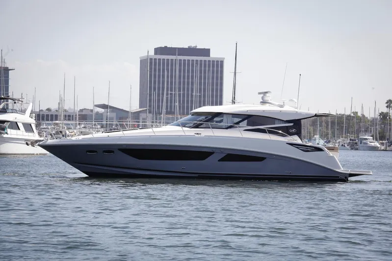 Baby Pie Yacht Photos Pics 2016 Sea Ray 470 Sundancer yacht cruising in a marina with cityscape background.