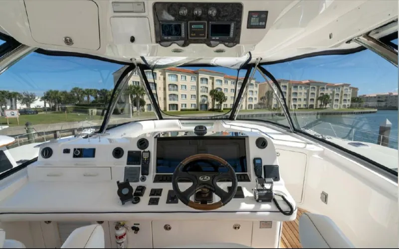  Yacht Photos Pics 2008 Sea Ray 58 Sedan Bridge helm with modern controls, overlooking waterfront buildings.