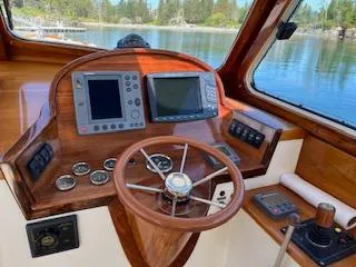 Free Will Yacht Photos Pics 2003 Hinckley Extended Hardtop Pilothouse 36 Picnic Boat helm with navigation instruments and wooden steering wheel.