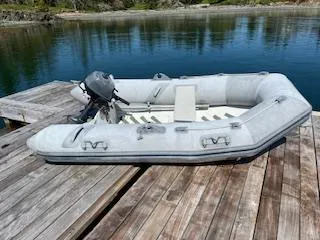 Free Will Yacht Photos Pics Inflatable boat with motor on wooden dock by calm water.