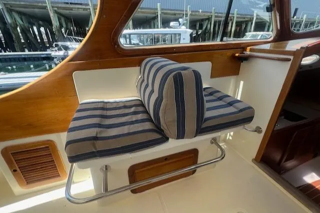 Free Will Yacht Photos Pics 2003 Hinckley Extended Hardtop Pilothouse 36 interior with striped cushioned seating.