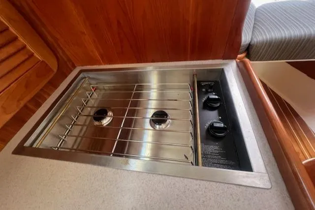 Free Will Yacht Photos Pics 2003 Hinckley Pilothouse 36 Picnic Boat stove with two burners and wooden cabinetry.