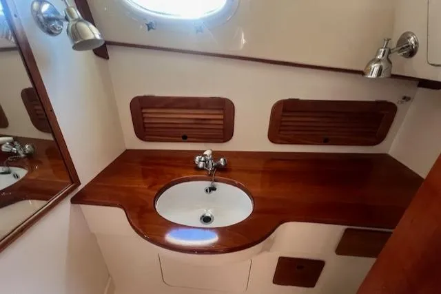 Free Will Yacht Photos Pics 2003 Hinckley Pilothouse 36 boat bathroom with wooden countertop and sink.