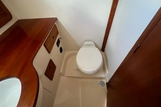 Free Will Yacht Photos Pics 2003 Hinckley Pilothouse 36 boat bathroom with wooden cabinetry and toilet.
