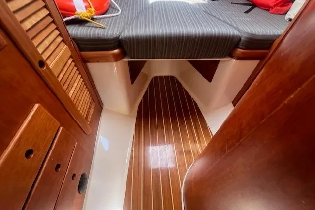 Free Will Yacht Photos Pics 2003 Hinckley Extended Hardtop Pilothouse 36 interior with wood finish and striped upholstery.