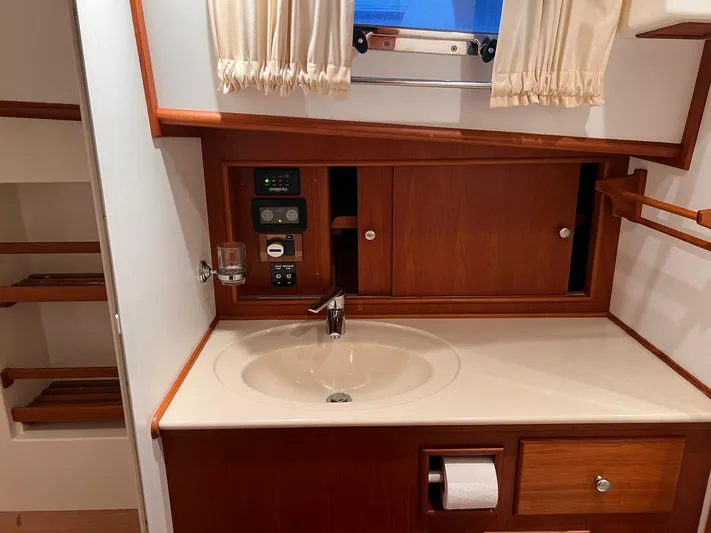  Yacht Photos Pics Luxurious 2004 Grand Banks Eastbay 54 SX yacht bathroom with wooden cabinetry and modern fixtures.