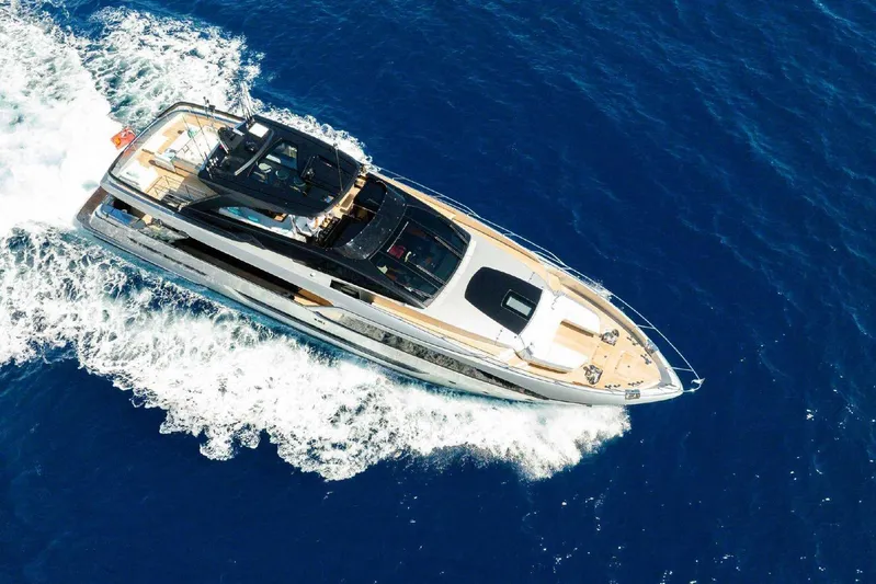 Clarity Yacht Photos Pics Aerial view of 2022 Riva 90' Argo yacht cruising on blue ocean waters.