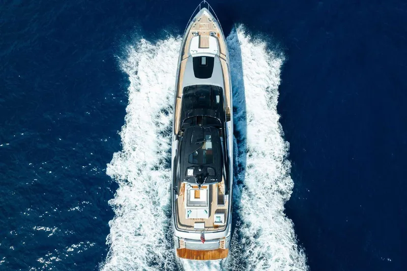 Clarity Yacht Photos Pics Aerial view of 2022 Riva 90' Argo yacht cruising on blue ocean waters.