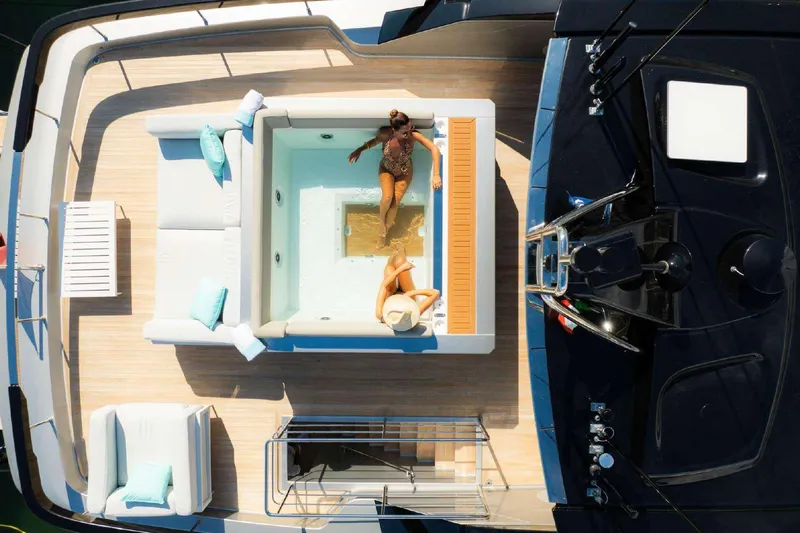 Clarity Yacht Photos Pics Aerial view of luxurious 2022 Riva 90' Argo yacht with sunbathing area and jacuzzi.