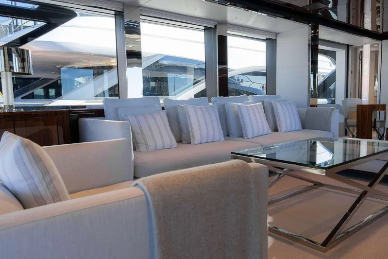 Clarity Yacht Photos Pics Luxurious interior of 2022 Riva 90' Argo yacht with elegant seating and glass table.