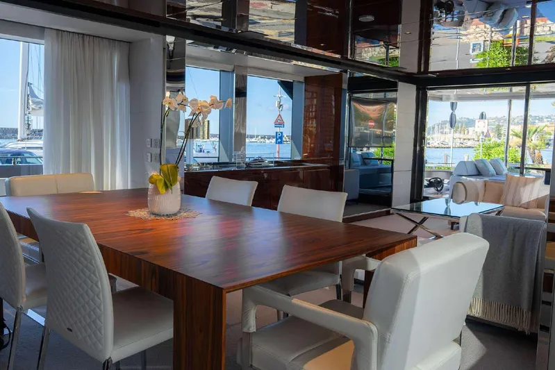 Clarity Yacht Photos Pics Luxurious interior of 2022 Riva 90' Argo yacht with elegant dining area and waterfront view.