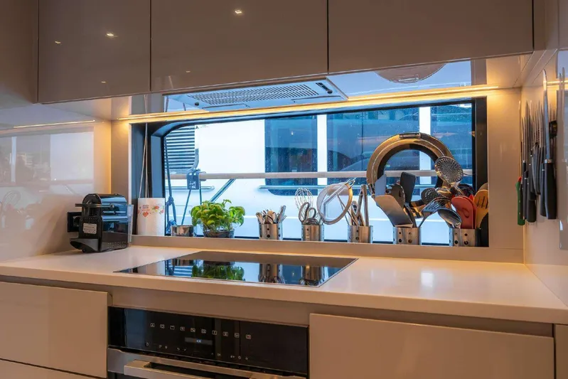 Clarity Yacht Photos Pics Modern kitchen interior on 2022 Riva 90' Argo yacht with sleek appliances and utensils.