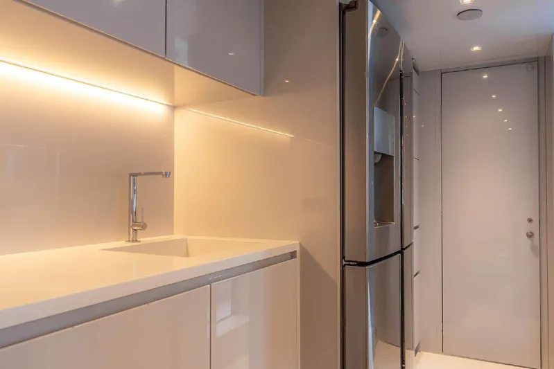 Clarity Yacht Photos Pics Modern kitchen interior on 2022 Riva 90' Argo yacht, featuring sleek design and lighting.