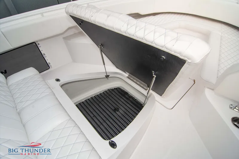  Yacht Photos Pics 2023 Fountain 34 CC boat interior with open storage compartment and white quilted seating.
