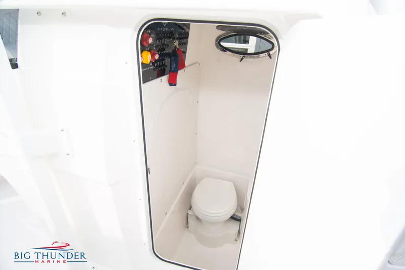  Yacht Photos Pics 2023 Fountain 34 CC boat interior with compact marine toilet and control panel.