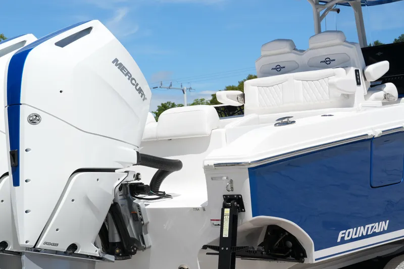  Yacht Photos Pics 2023 Fountain 34 Center Console boat with Mercury engine, featuring sleek blue and white design.