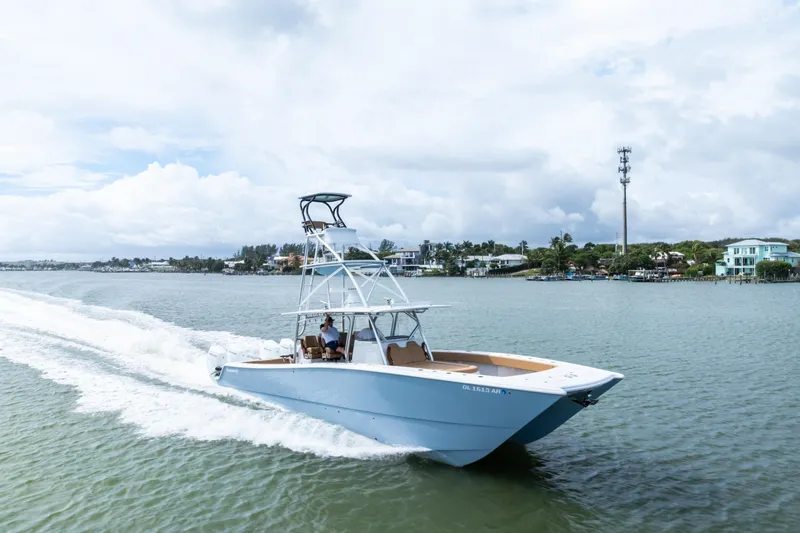  Yacht Photos Pics 2025 Freeman LR boat cruising on a scenic waterway under a cloudy sky.