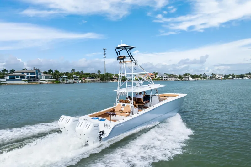  Yacht Photos Pics 2025 Freeman LR boat cruising on a sunny day near coastal homes.