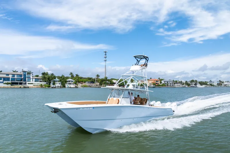  Yacht Photos Pics 2025 Freeman LR boat cruising on a scenic waterway with coastal homes in the background.