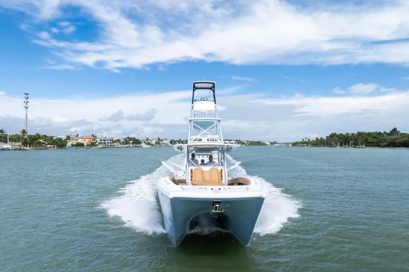  Yacht Photos Pics 2025 Freeman LR boat cruising on a scenic waterway under a clear blue sky.