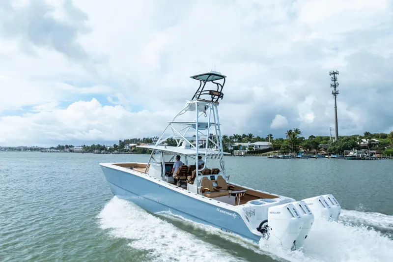  Yacht Photos Pics 2025 Freeman LR boat cruising on a scenic waterway under a cloudy sky.