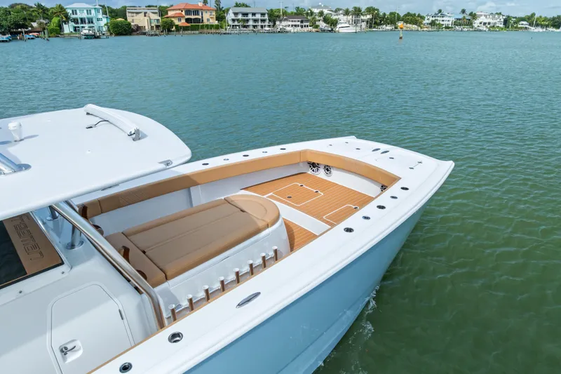  Yacht Photos Pics 2025 Freeman LR boat with sleek design on calm water near coastal homes.