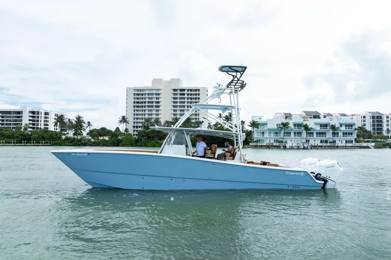  Yacht Photos Pics 2025 Freeman LR boat on water near modern waterfront buildings.