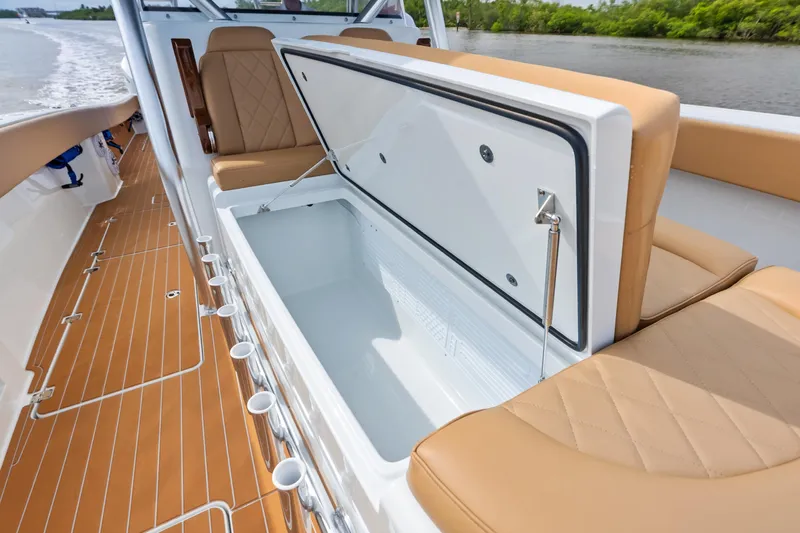  Yacht Photos Pics Open storage compartment on 2025 Freeman LR boat with tan seating and wooden deck.