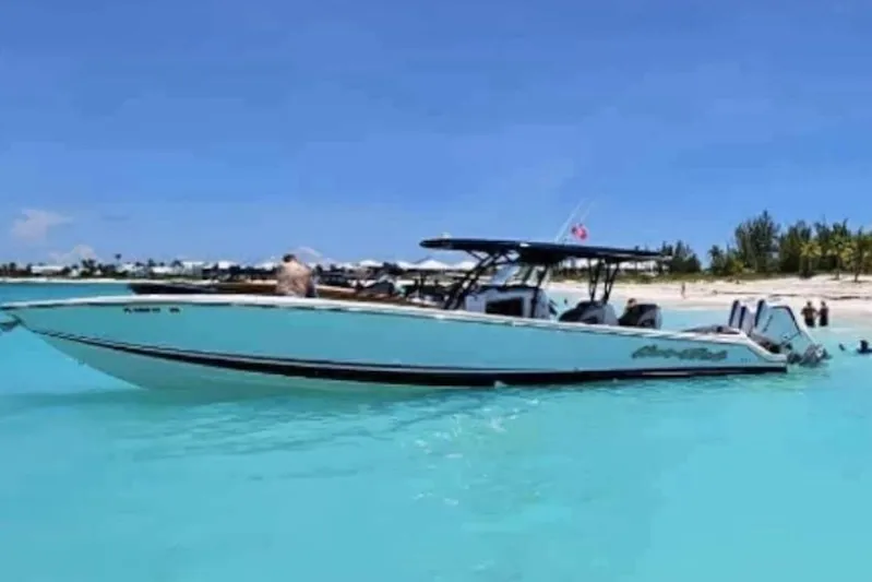  Yacht Photos Pics 2025 Nor-Tech 390 Sport Center Console boat in turquoise waters near a sandy beach.