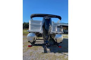 2026 Sun Tracker Party Barge 18 DLX pontoon boat, rear view with motor, outdoors.