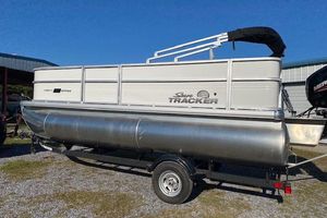 2026 Sun Tracker Party Barge 18 DLX pontoon boat on trailer, parked outdoors.
