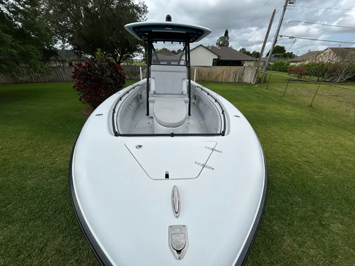  Yacht Photos Pics 2024 Contender 28 Tournament boat on grass, showcasing sleek design and spacious deck.