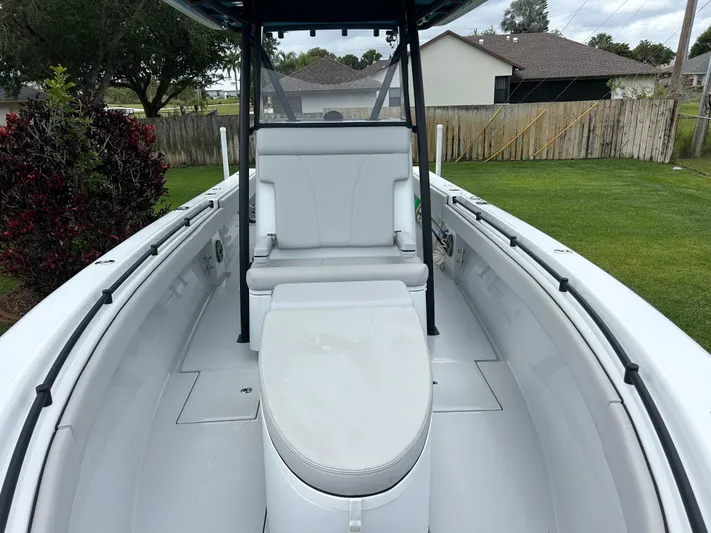  Yacht Photos Pics 2024 Contender 28 Tournament boat interior with seating and console, parked in a grassy yard.
