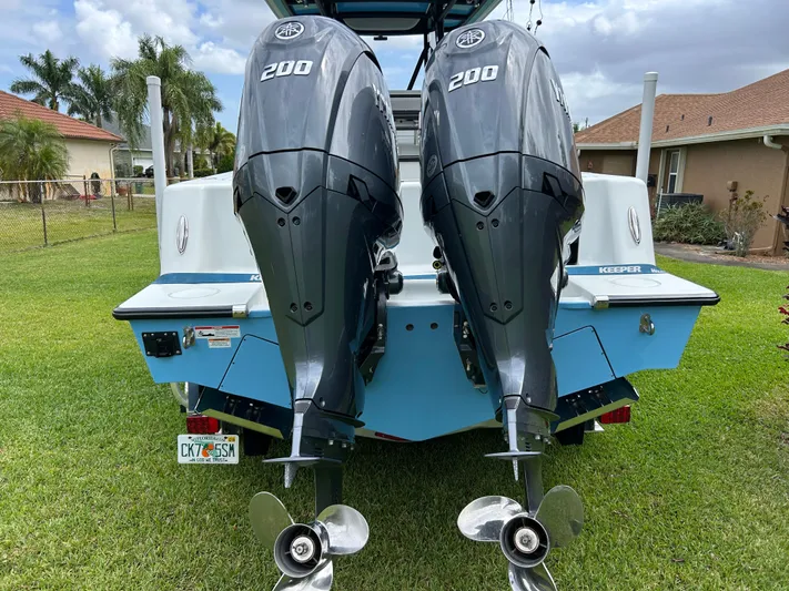  Yacht Photos Pics 2024 Contender 28 Tournament boat with dual 200 horsepower engines, parked on grass.