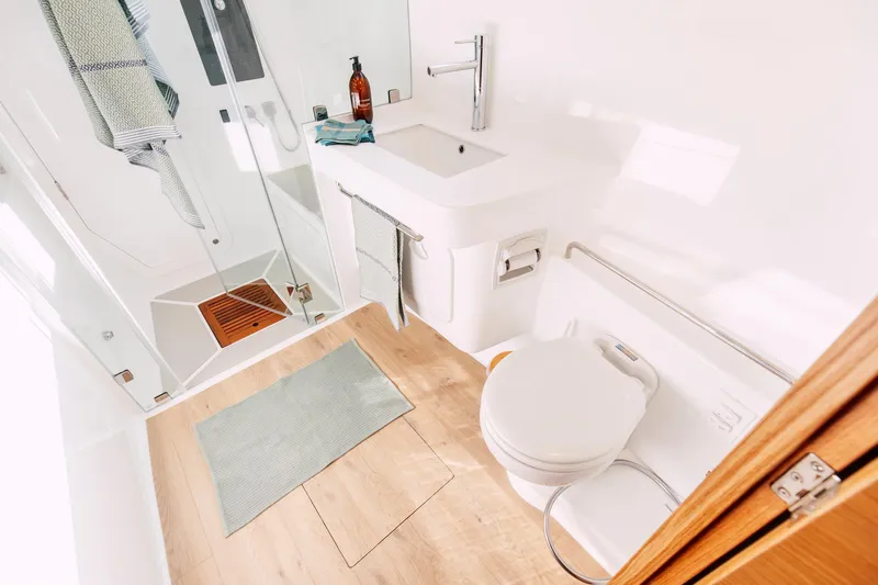 Vision 444 Yacht Photos Pics Modern bathroom in Vision 444 model, 2026, featuring shower, sink, and toilet with wooden accents.