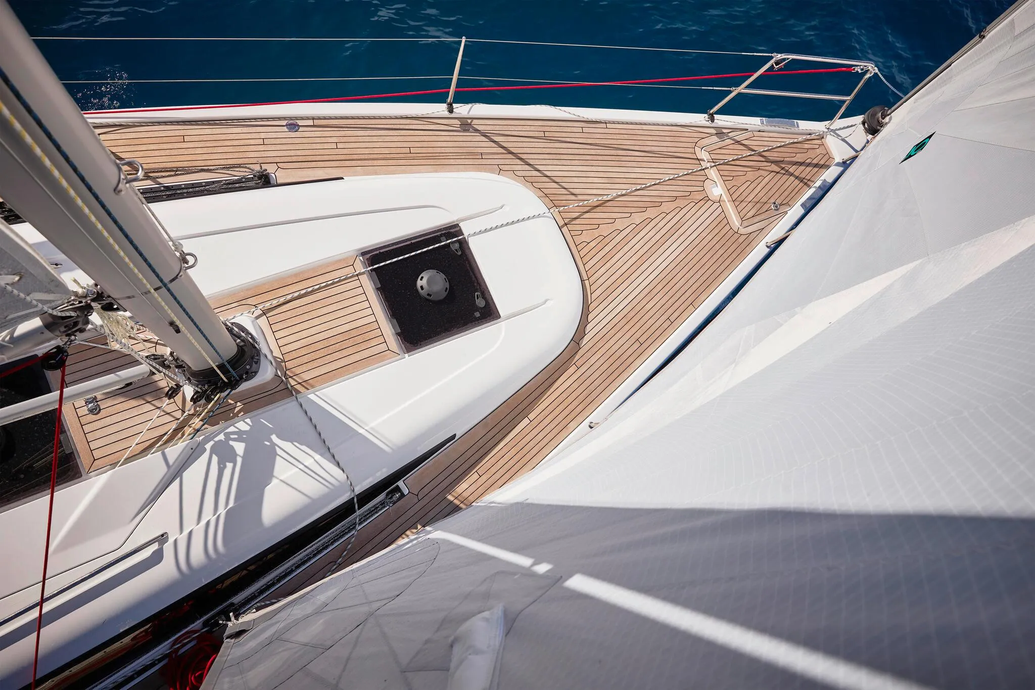 2025 Dehler 38 SQ sailboat deck with wooden finish and white sails.