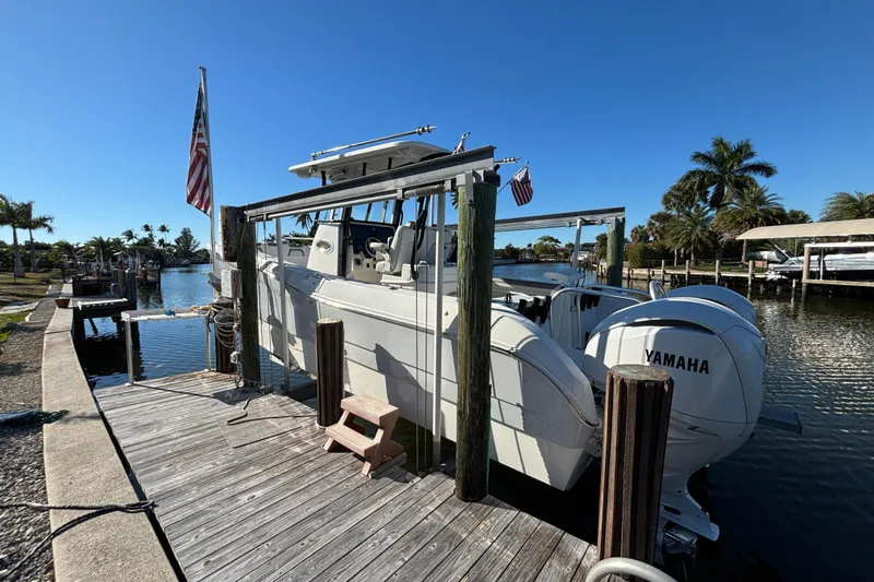  Yacht Photos Pics 2023 World Cat 295 CC boat docked with Yamaha engines, sunny day, palm trees in background.
