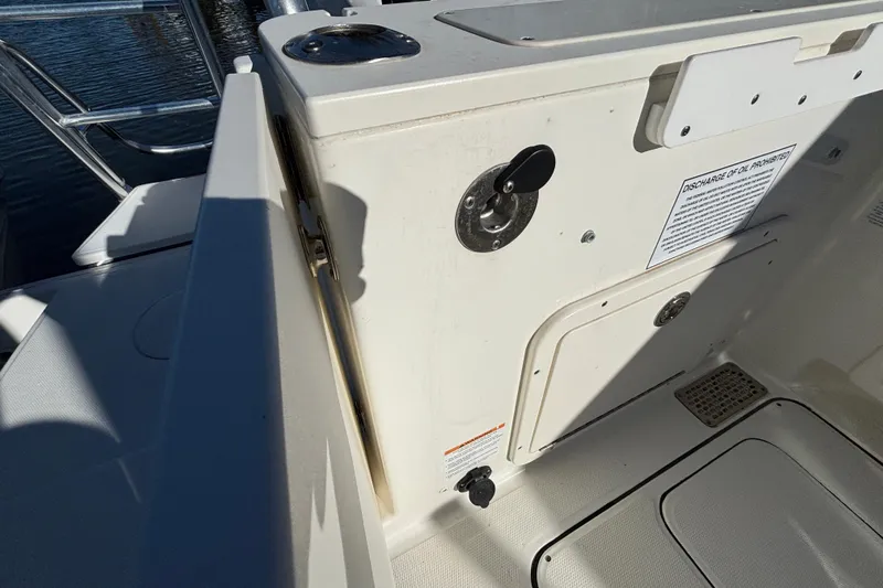  Yacht Photos Pics 2023 World Cat 295 CC boat interior detail with storage compartment and safety notice.