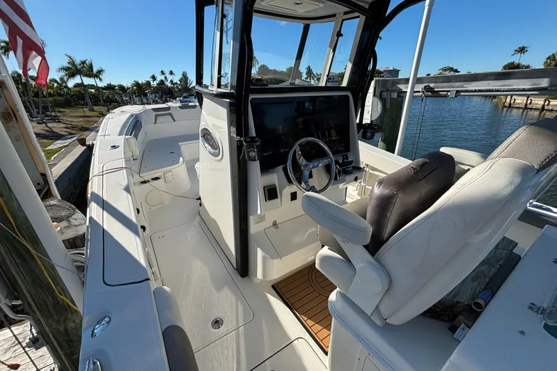 Yacht Photos Pics 2023 World Cat 295 CC boat interior with helm, seating, and waterfront view.