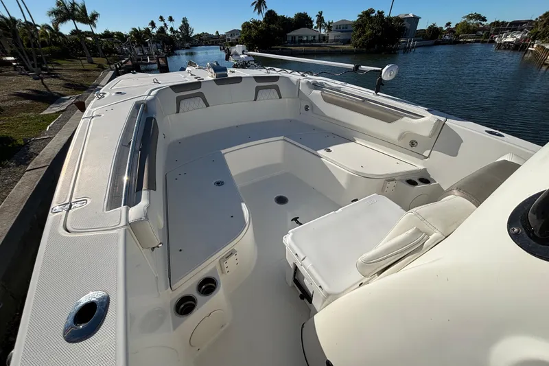  Yacht Photos Pics 2023 World Cat 295 CC boat interior with spacious seating and storage, docked by a scenic canal.