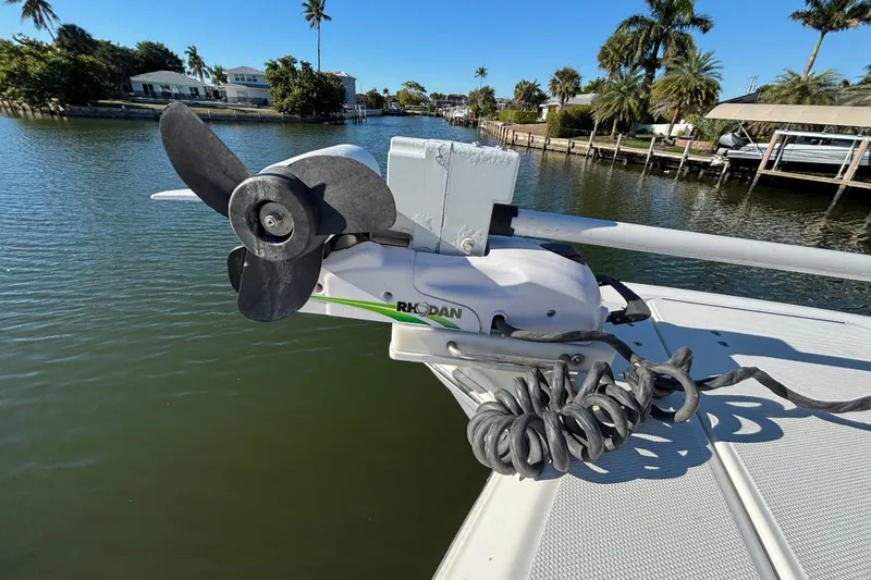  Yacht Photos Pics 2023 World Cat 295 CC boat with Rhodan trolling motor on a sunny waterfront.