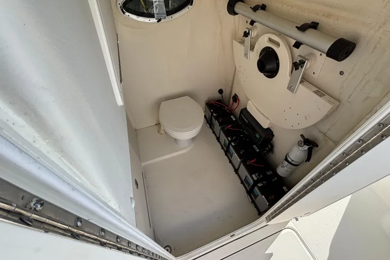  Yacht Photos Pics 2023 World Cat 295 CC boat interior with toilet, batteries, and fire extinguisher.
