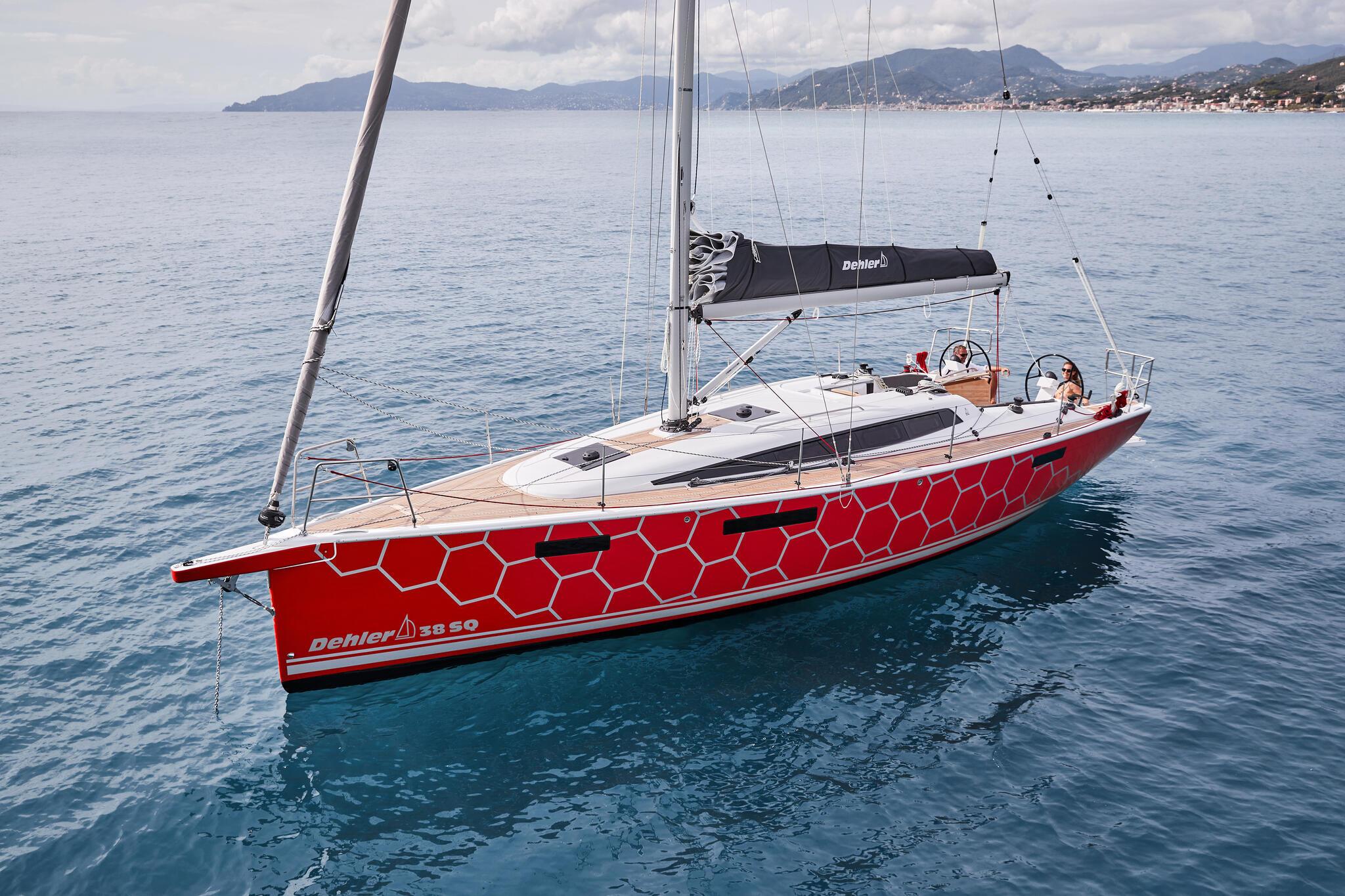2025 Dehler 38 SQ sailboat with red honeycomb design on calm sea.