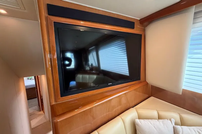 Breakaway Yacht Photos Pics Interior of 2004 Viking 56 Convertible yacht with mounted TV and beige seating.