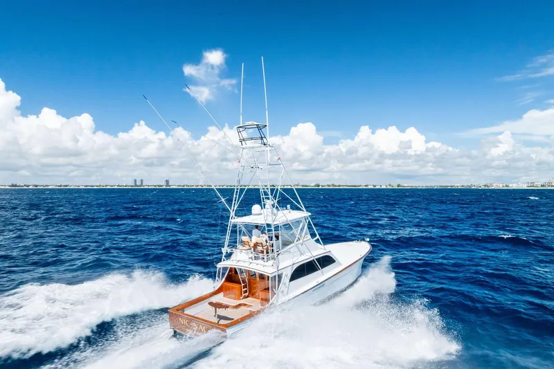 Nic-nac Yacht Photos Pics 1977 Merritt Sportfish yacht cruising on open ocean under clear blue sky.