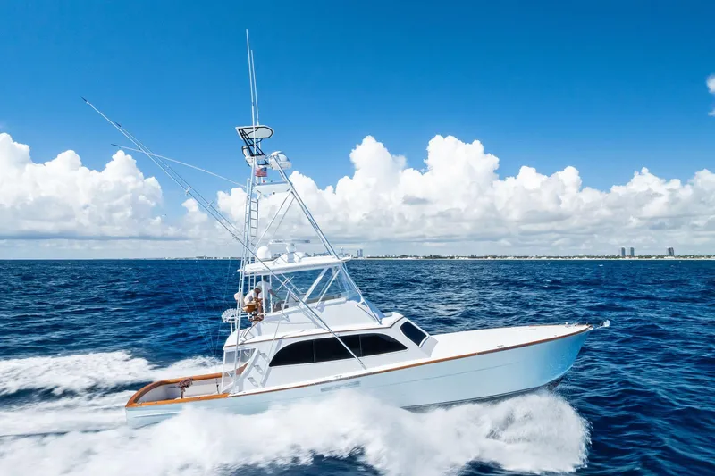 Nic-nac Yacht Photos Pics 1977 Merritt Sportfish yacht cruising on open ocean under clear blue sky.